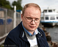 File Photo of Oleg Kashin Outdoors with Boat and Water in Background