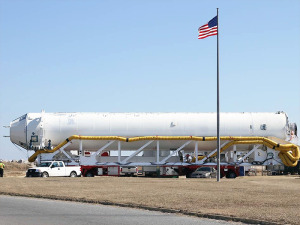 Antares Rocket on Side on Transport Vehicle As U.S. Flag Flies on Pole