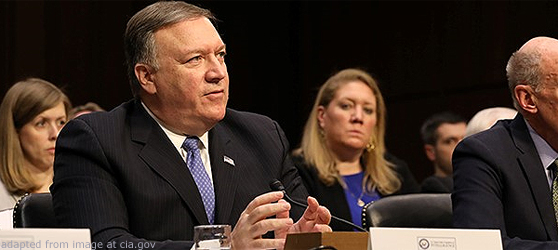 File Photo of Mike Pompeo Seat at Table During Congressional Testimony, with Specators in the Background