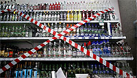 Shelf of Alcoholic Beverages with Red and White Tape Across It