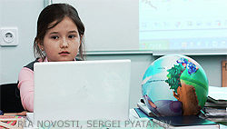 File Photo of Little Girl at Computer Next to Globe