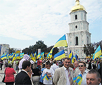 File Photo of Ukrainians with Ukrainian Flag in Public Square Near Tower with Golden Dome