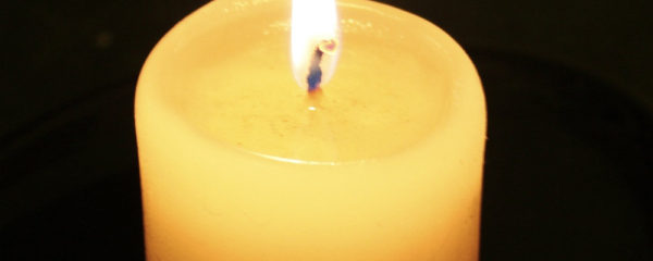Lit Candle with Reflection and Dark Background