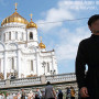 File Photo of Russian Orthodox Cathedral with Man in Religious Garb in Foreground
