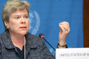 File Photo of Rose Gottemoeller Gesturing, Sitting Behind Placard Reading United States of America
