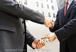 File Photo of Two Persons Shaking Hands and Exchanging Cash