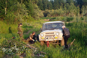File Photo of People Working on Car in Siberian Woodlands