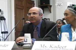 File Photo of William Browder Seated at Table with Microphone as Woman Listens, with Image Watermark Saying Presented by Library of Congress with U.S. House of Representatives Seal, adapted from image at house.gov