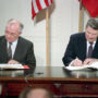 File Photo of Mikhail Gorbachev and Ronald Reagan at Table Signing Documents
