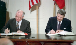 File Photo of Mikhail Gorbachev and Ronald Reagan at Table Signing Documents