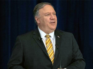 Cropped version of File Photo of Mike Pompeo Standing and Speaking, with U.S. Flag to Side, adapted from image at usembassy.gov