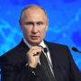 File Photo of Vladimir Putin at Podium with United Russia Logo, Gesturing