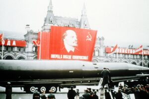 Soviet ICBM in Parade With Soviet Flag Bearing Image of Lenin in Background