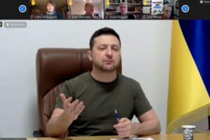Screenshot file photo of Volodymyr Zelensky Gesturing, from Congressional Teleconference, adapted from image at doggett.house.gov
