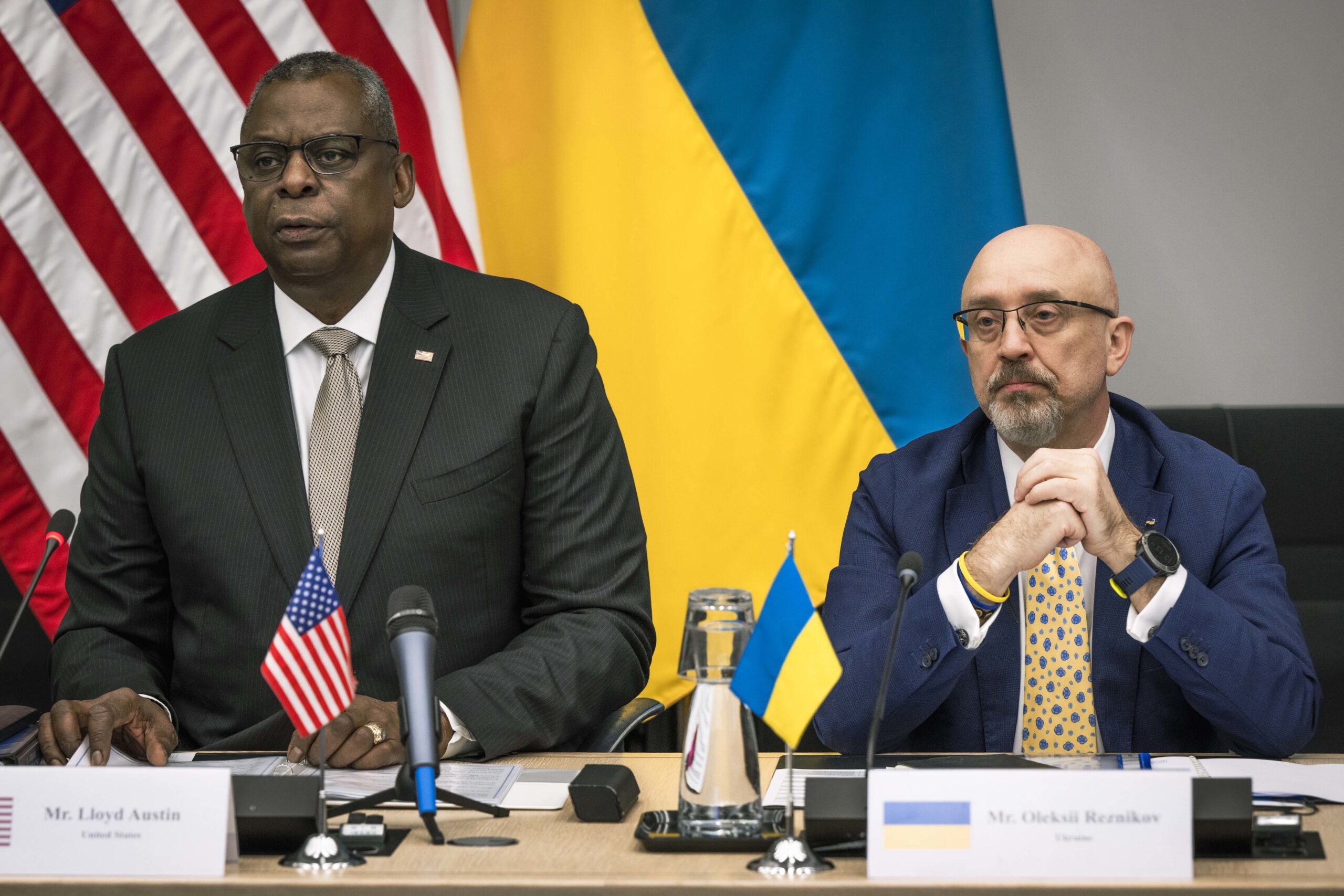 File photo of Lloyd J. Austin III and Oleksii Reznikov seated at table, with U.S. and Ukrainian Flags Behind, adapted from image at defense.gov with photo credit to DOD and Chad J. McNeeley)