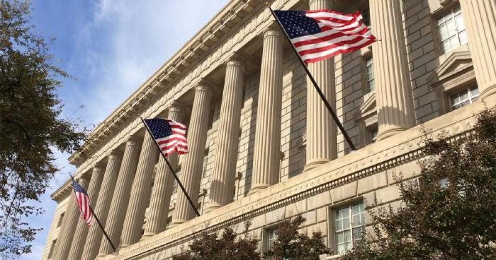 File Photo of Portion of U.S. Department of Commerce Headquarters Building Facade with U.S. Flags, adapted from commerce.gov image